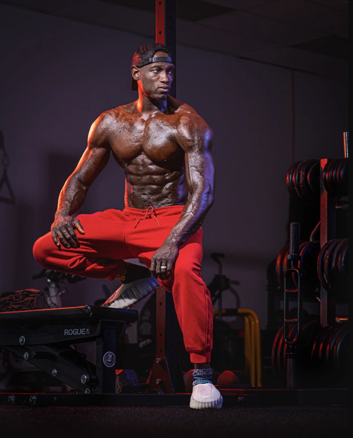 Coach JR in a focused crouch beside a gym bench